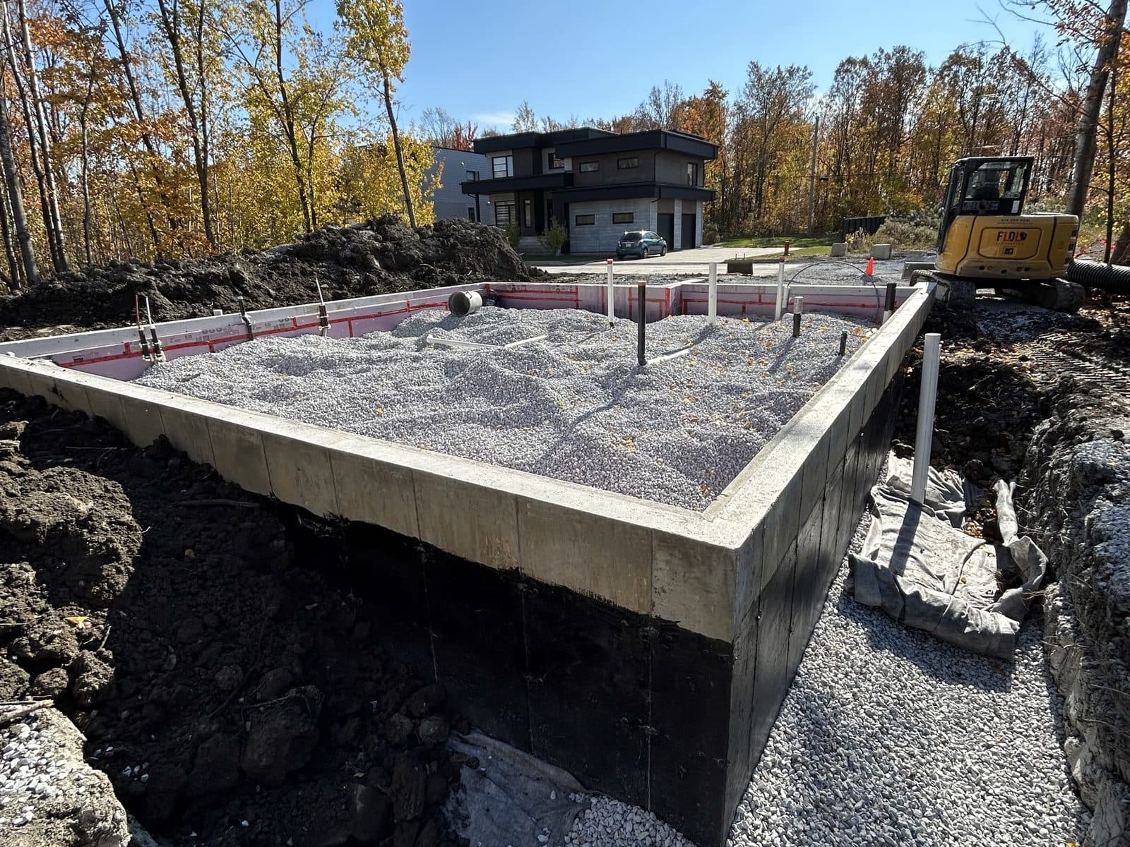 Pelle mécanique creusant l'excavation d'une nouvelle fondation résidentielle à Saint-Jean-sur-Richelieu